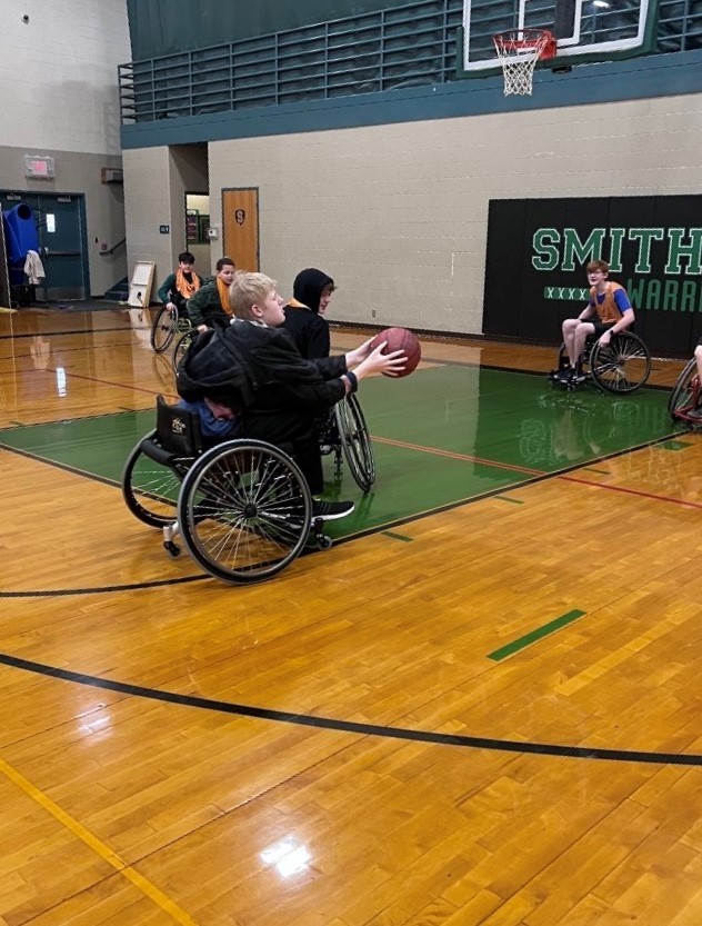 Student in wheel chair shoots basket