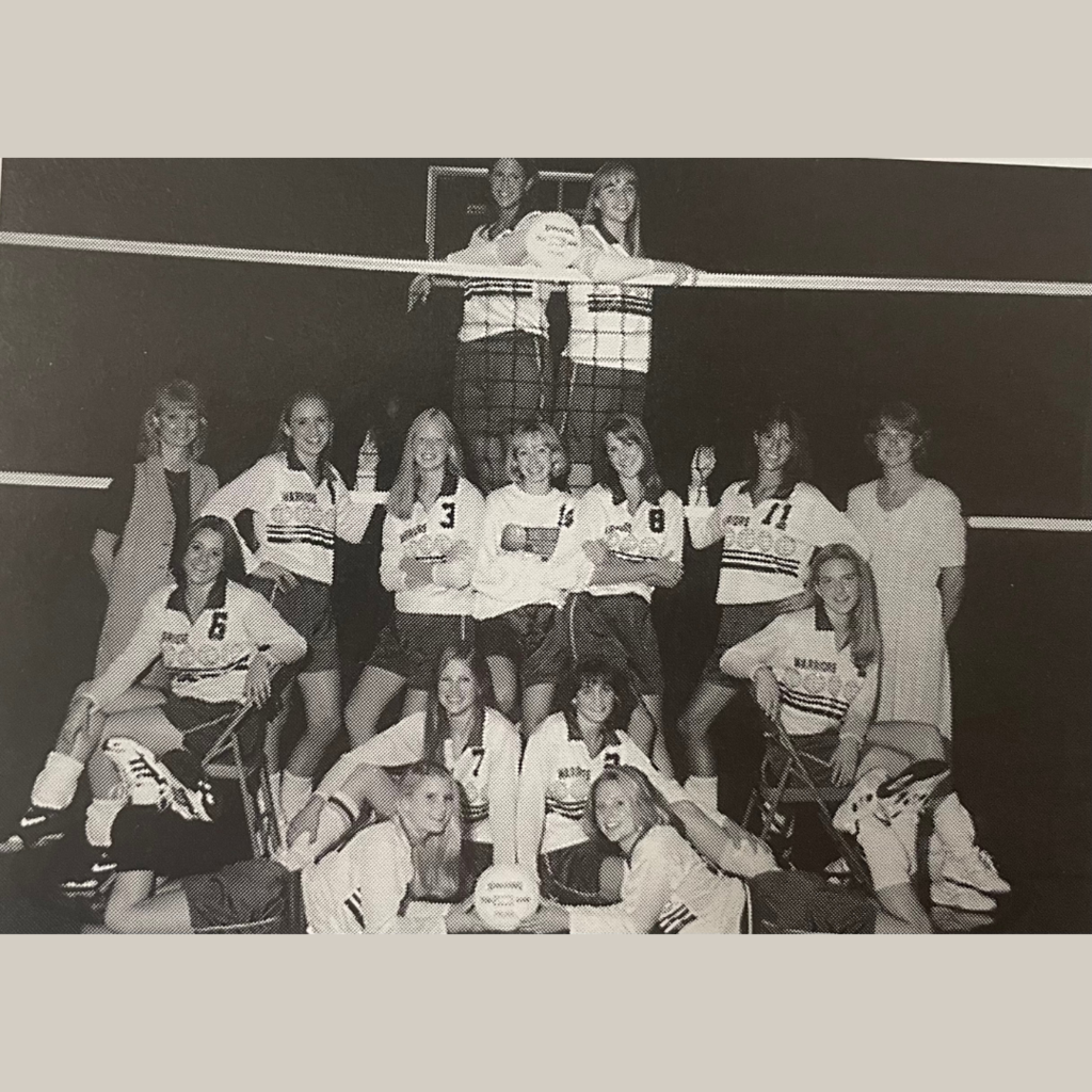 Volleyball Players posed next to net.